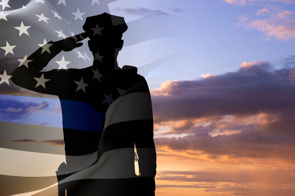 Silhouette of a police officer against the sunset. American flag with police support symbol. Thin blue line