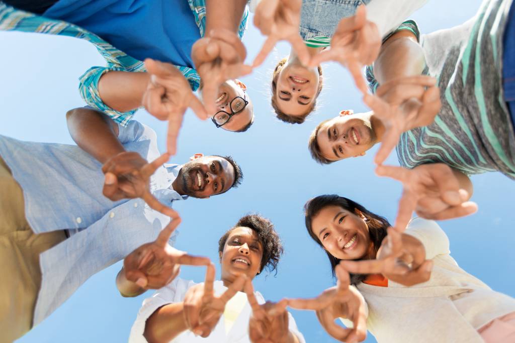 happy friends showing peace standing in circle