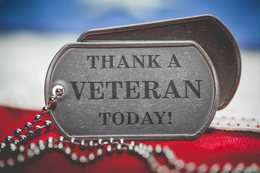 Worn US American dog tags on USA flag with Thank a Veteran Today