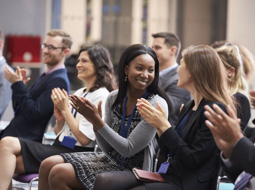 A group of diverse people in the audience of a educational conference